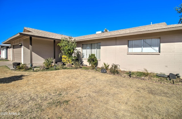 view of side of property with a garage and a lawn