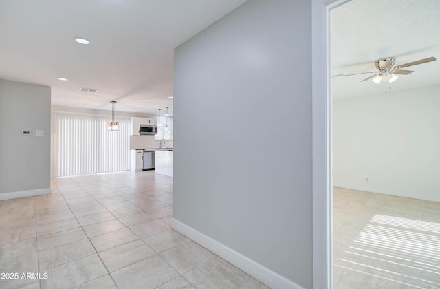 hall featuring light tile patterned floors, a chandelier, and sink