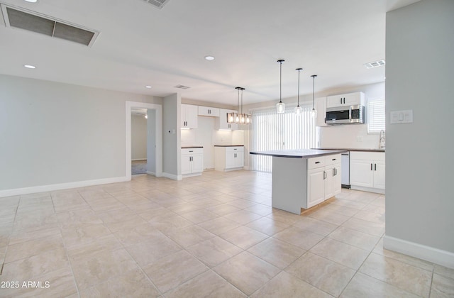 kitchen featuring a kitchen island, pendant lighting, backsplash, and white cabinets