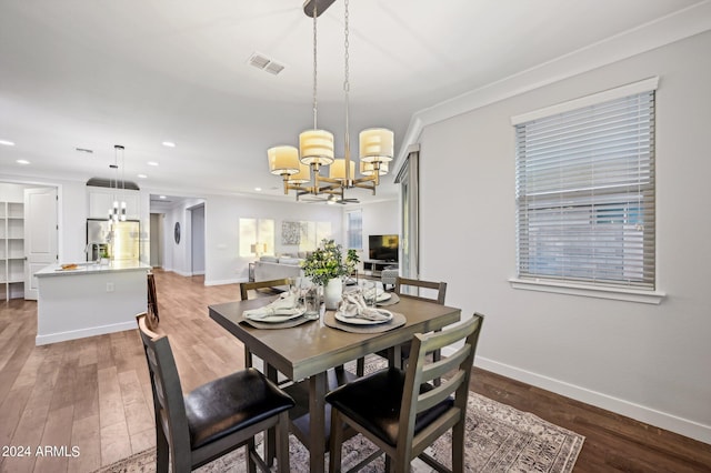 dining room with crown molding, a chandelier, and wood-type flooring