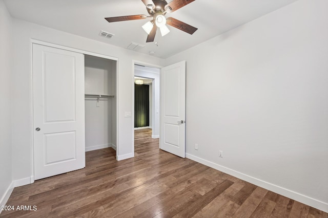 unfurnished bedroom with a closet, ceiling fan, and dark hardwood / wood-style floors