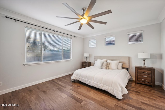 bedroom featuring ceiling fan, crown molding, and dark wood-type flooring