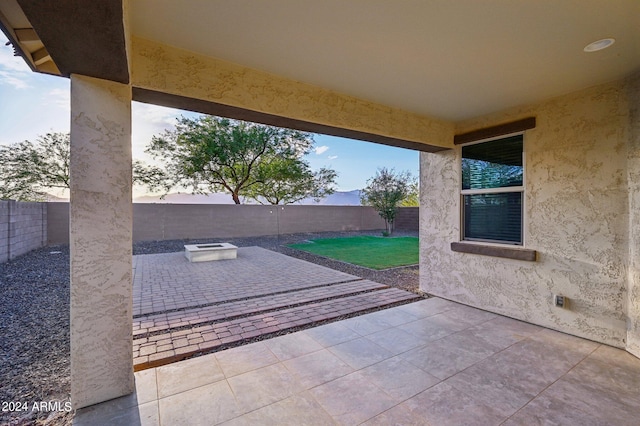 patio terrace at dusk featuring a fire pit