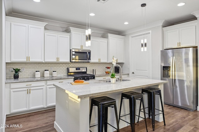 kitchen featuring white cabinets, sink, stainless steel appliances, and an island with sink