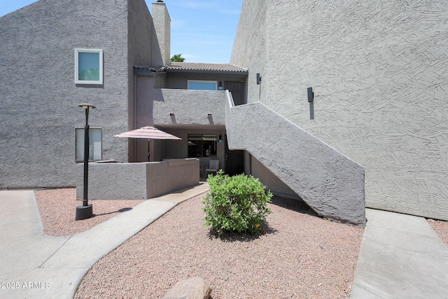 view of home's exterior featuring stucco siding and a chimney