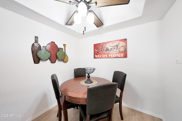dining room featuring ceiling fan, baseboards, and light wood finished floors