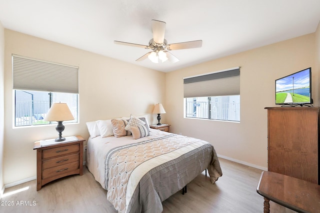 bedroom featuring light wood-style floors, baseboards, and a ceiling fan
