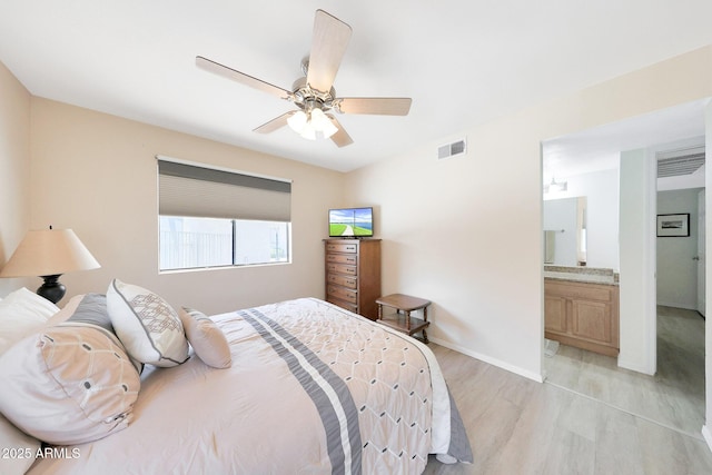 bedroom with light wood-style floors, baseboards, ceiling fan, and connected bathroom