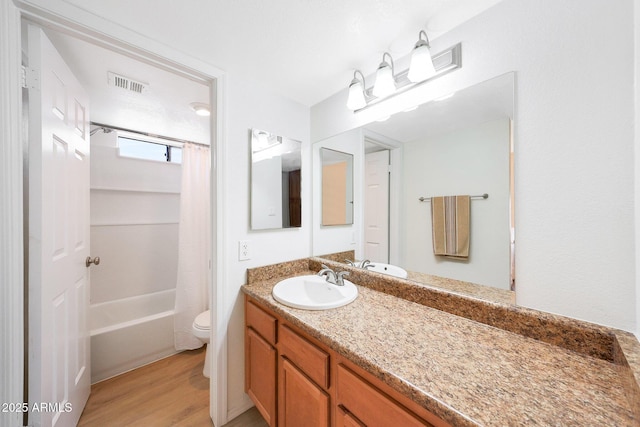 bathroom with wood finished floors, vanity, toilet, and shower / tub combo