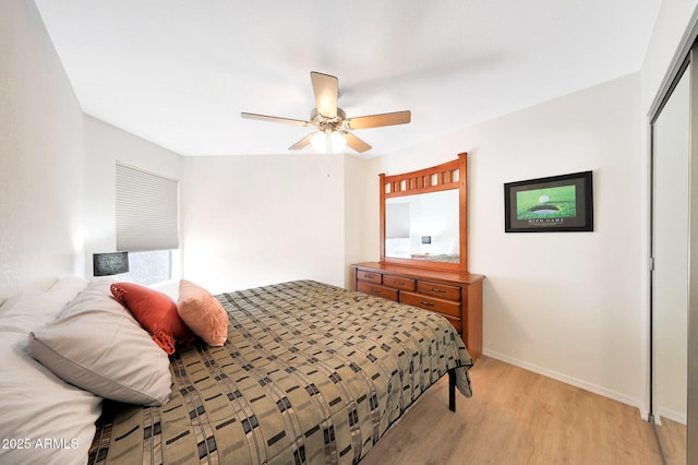 bedroom featuring light wood-style flooring, a closet, baseboards, and ceiling fan