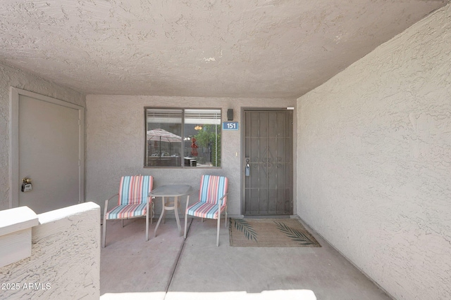 property entrance featuring stucco siding and a patio