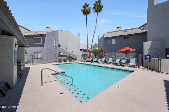 community pool with a patio and a residential view