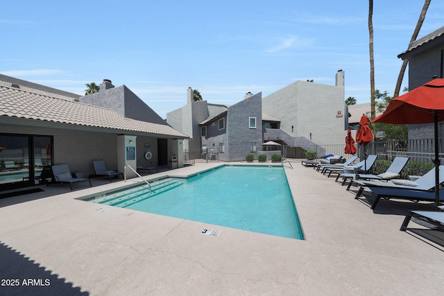 community pool with a patio and a residential view