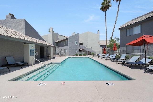 community pool with a patio and a residential view