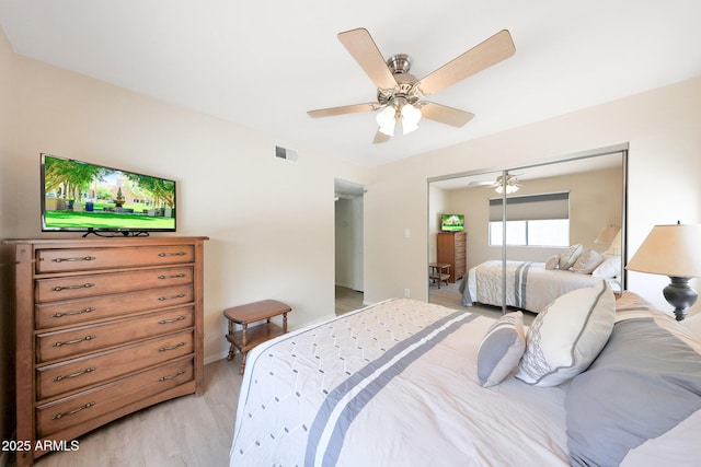 bedroom featuring light wood-type flooring, a closet, a ceiling fan, and baseboards