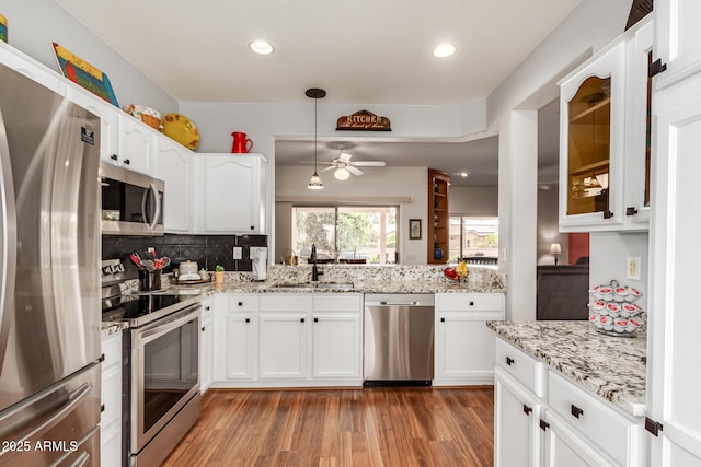 16331 W Tierra Way, Surprise, AZ 85374 - kitchen featuring a sink, backsplash, light wood finished floors, a ceiling fan, and appliances with stainless steel finishes