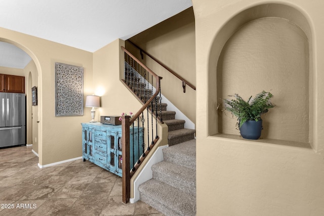 3828 S Verbena Ave, Gilbert, AZ 85297 - stairway with arched walkways, baseboards, and stone finish floor