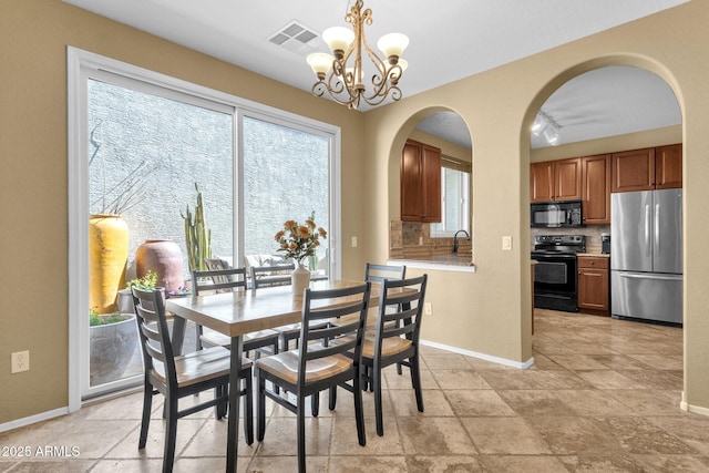 3828 S Verbena Ave, Gilbert, AZ 85297 - dining room with baseboards, arched walkways, a chandelier, and visible vents