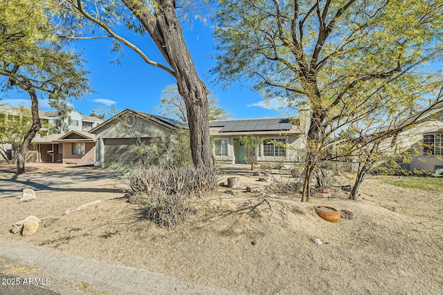 view of front of house featuring a garage and solar panels