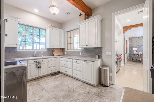 kitchen with beamed ceiling, a sink, visible vents, and white cabinetry