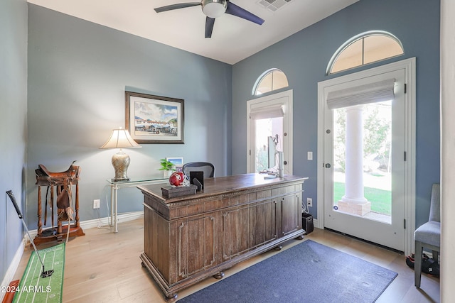 office area with light wood-style floors, ceiling fan, and baseboards