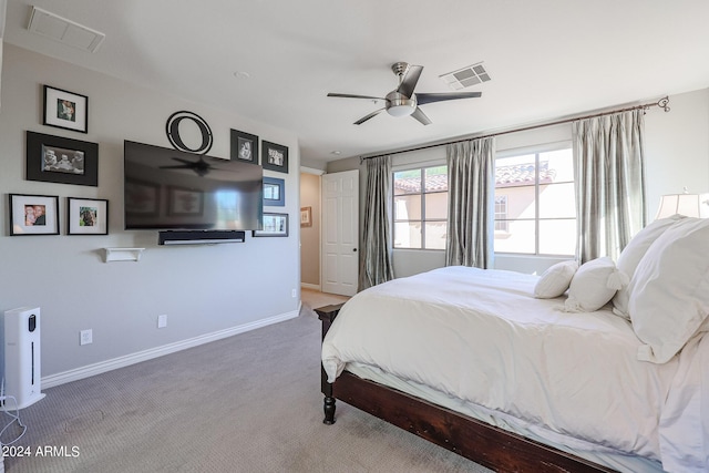 carpeted bedroom featuring baseboards, visible vents, and a ceiling fan