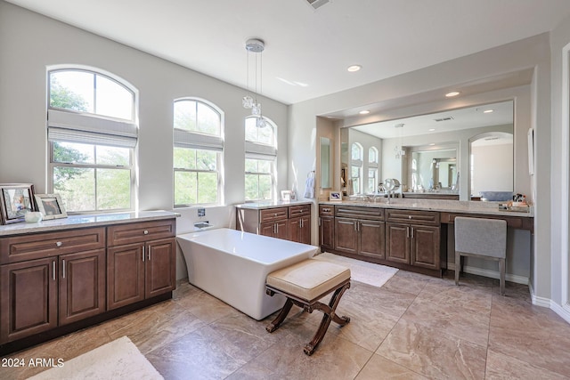 bathroom with a freestanding tub, visible vents, two vanities, and recessed lighting