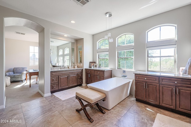 bathroom featuring a freestanding tub, recessed lighting, a sink, two vanities, and visible vents