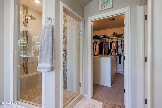 full bathroom featuring a shower stall, a spacious closet, and visible vents