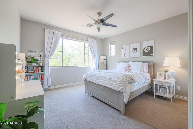 bedroom featuring a ceiling fan, light colored carpet, visible vents, and baseboards