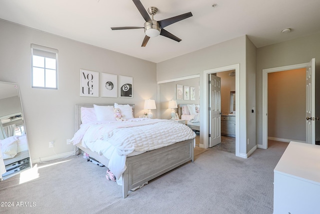 bedroom with light carpet, ceiling fan, ensuite bath, and baseboards