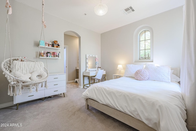 bedroom featuring visible vents, arched walkways, baseboards, and light colored carpet