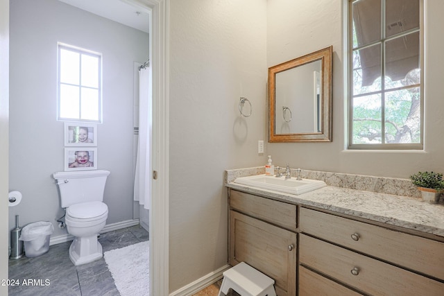 full bath featuring baseboards, vanity, and toilet