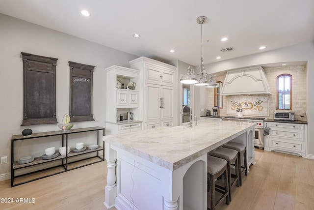 kitchen with white cabinets, backsplash, light wood finished floors, and open shelves