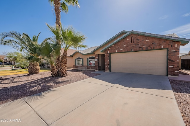 view of front of property featuring an attached garage, stucco siding, concrete driveway, and brick siding