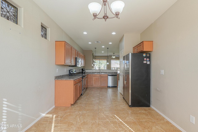 kitchen featuring an inviting chandelier, appliances with stainless steel finishes, decorative light fixtures, and sink