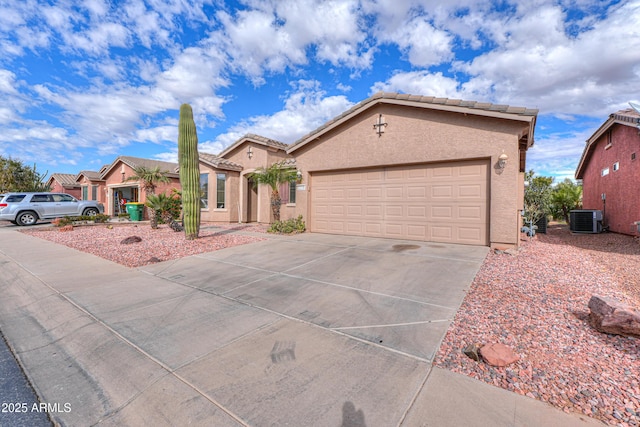 ranch-style house featuring central AC unit and a garage