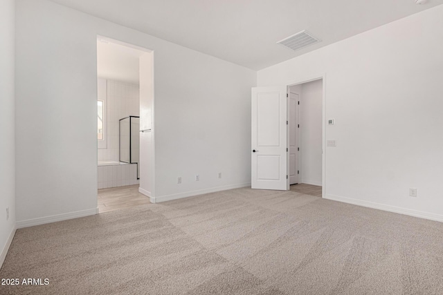 empty room with baseboards, visible vents, and light colored carpet