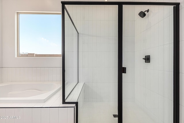 bathroom with a stall shower and a garden tub