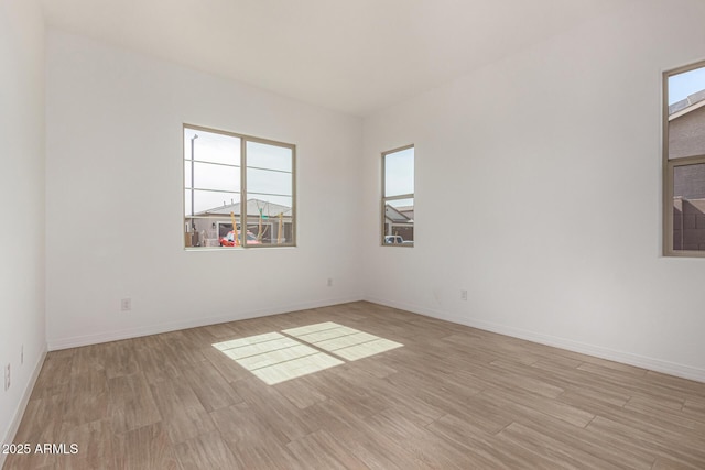 spare room with light wood finished floors and baseboards