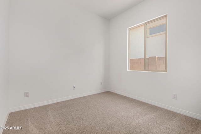 carpeted empty room featuring baseboards