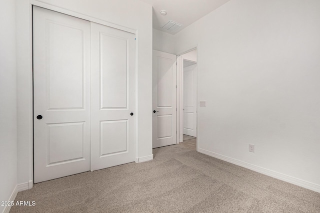 unfurnished bedroom featuring a closet, carpet flooring, visible vents, and baseboards