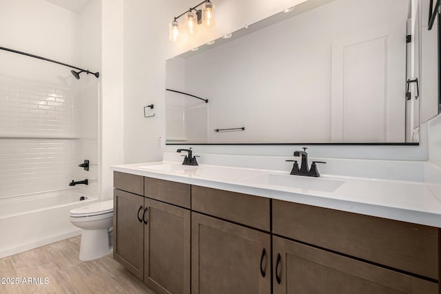 bathroom with shower / tub combination, a sink, toilet, and double vanity