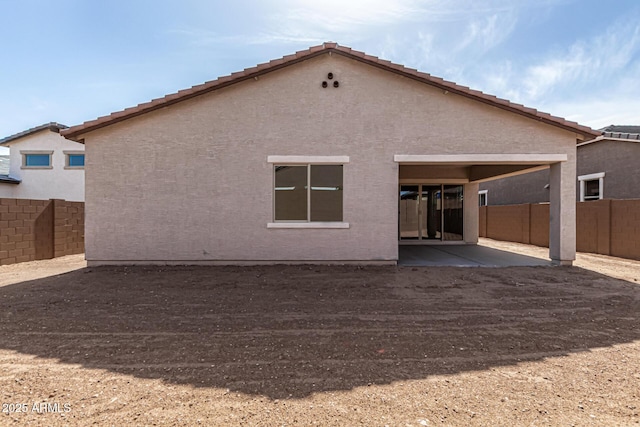 rear view of property featuring a fenced backyard, a patio, and stucco siding