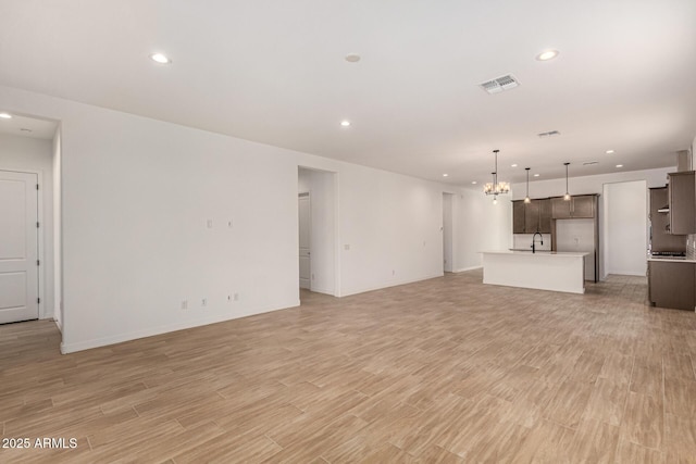 unfurnished living room with light wood-type flooring, visible vents, and recessed lighting