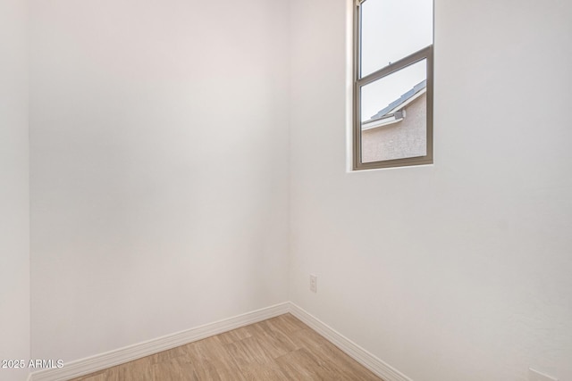 spare room featuring light wood-style floors and baseboards