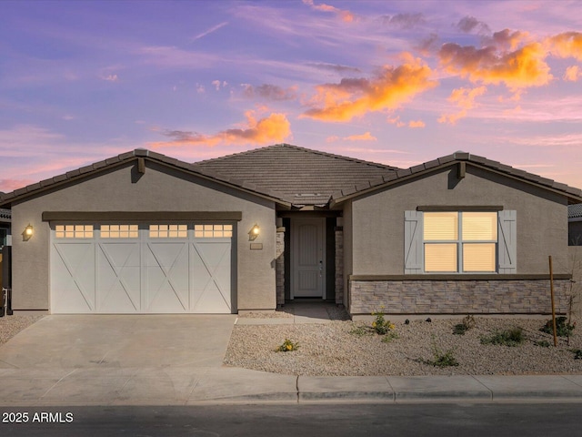 ranch-style house with a garage, driveway, a tile roof, and stucco siding
