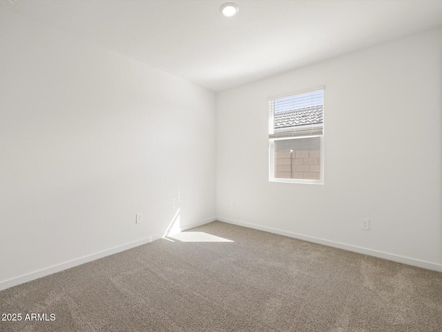 spare room with baseboards and carpet