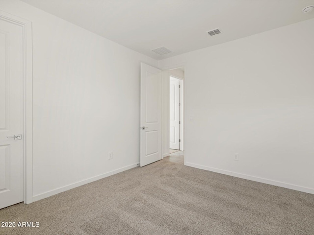 carpeted empty room featuring baseboards and visible vents