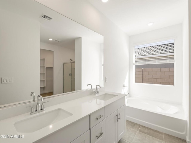 bathroom featuring a sink, tile patterned floors, a shower stall, and visible vents